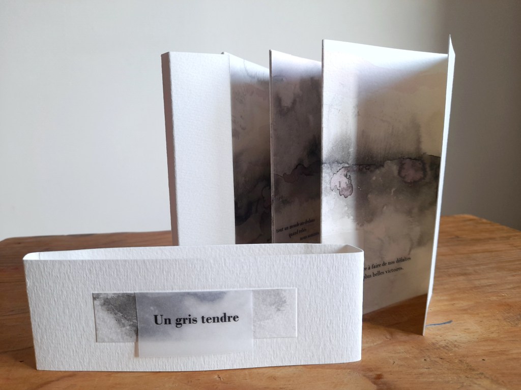 Un gris tendre - livre d'artiste de Yamina Viguier présenté ouvert avec le bandeau de reliure devant